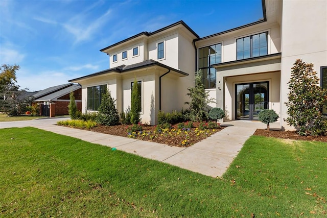 view of front facade with a front lawn and french doors