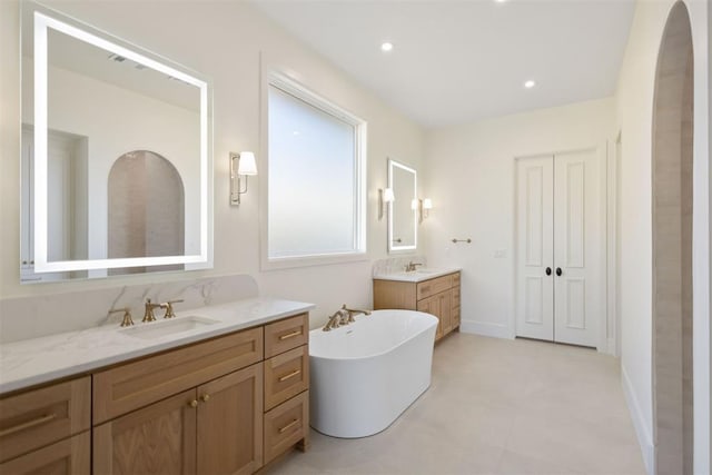 bathroom with a tub to relax in and vanity