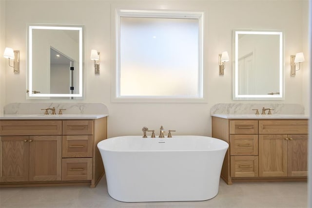 bathroom featuring vanity, a washtub, and tile patterned floors