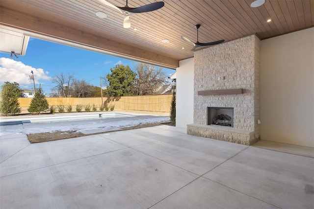 view of patio / terrace featuring an empty pool and an outdoor stone fireplace