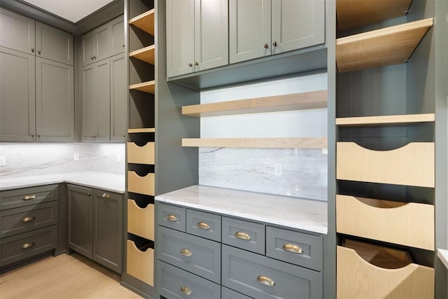 kitchen featuring backsplash, light hardwood / wood-style flooring, and gray cabinets