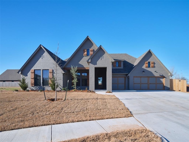 view of front of property featuring concrete driveway, brick siding, and fence