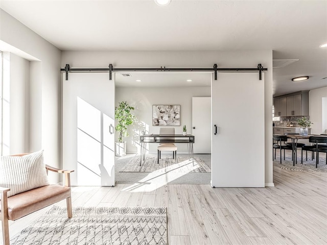 interior space with a barn door and light hardwood / wood-style floors