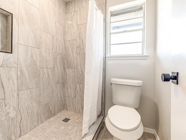 bathroom featuring toilet and a shower with curtain