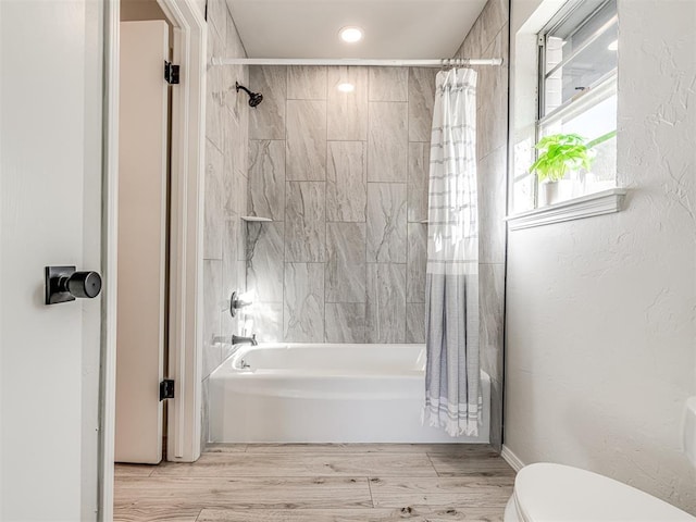 bathroom featuring toilet and shower / bathtub combination with curtain