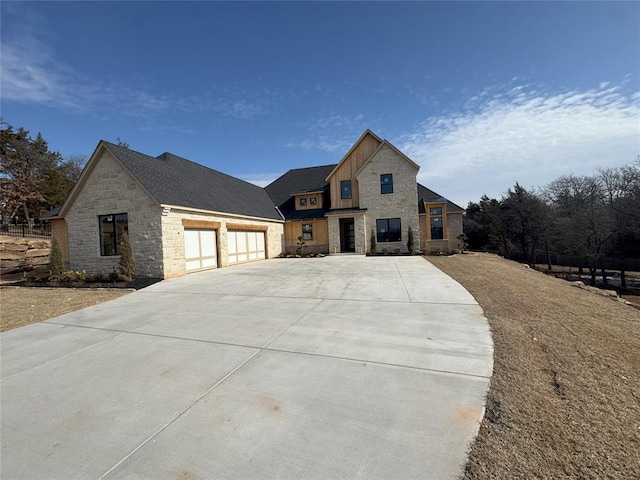 view of front facade featuring stone siding, concrete driveway, and a garage