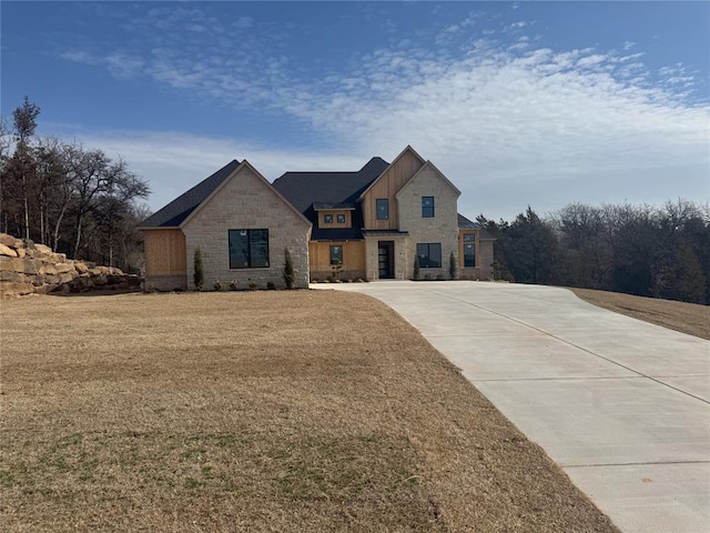 view of front of house featuring stone siding and a front lawn