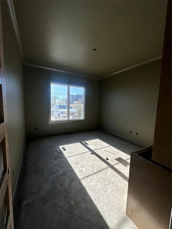 empty room featuring crown molding