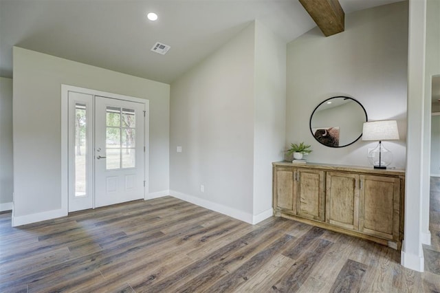 entrance foyer featuring beam ceiling and dark wood-type flooring