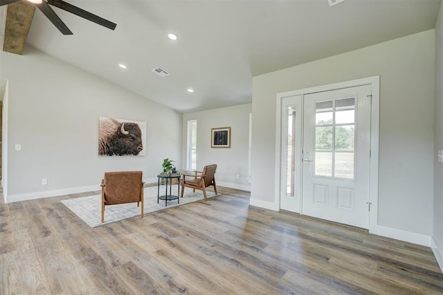 entryway with ceiling fan, wood-type flooring, and vaulted ceiling