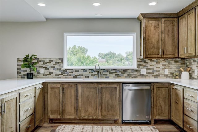 kitchen featuring decorative backsplash, sink, and stainless steel dishwasher