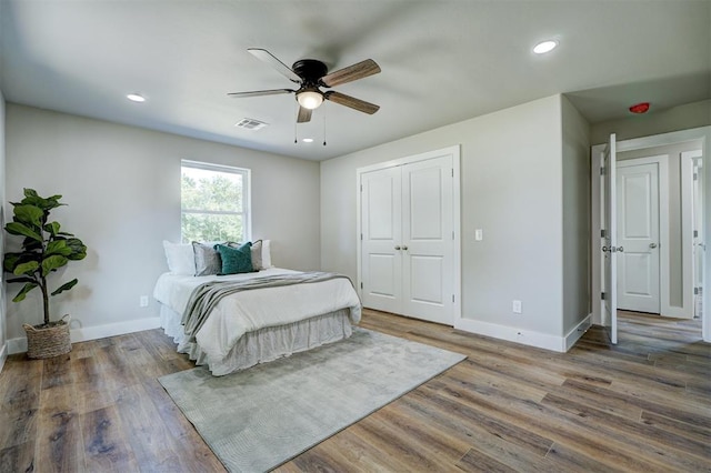 bedroom featuring hardwood / wood-style floors, ceiling fan, and a closet