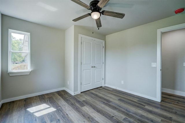 unfurnished bedroom with ceiling fan, dark hardwood / wood-style flooring, and a closet