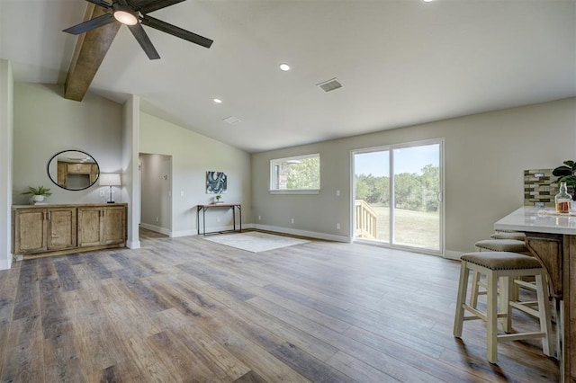 unfurnished living room with vaulted ceiling with beams, light hardwood / wood-style flooring, and ceiling fan