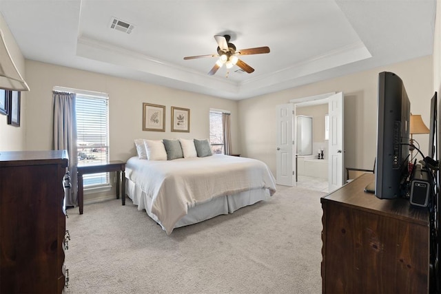 carpeted bedroom featuring ceiling fan, a raised ceiling, and ensuite bathroom