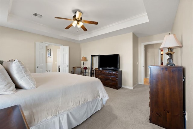 bedroom featuring a tray ceiling, ceiling fan, light colored carpet, and ornamental molding