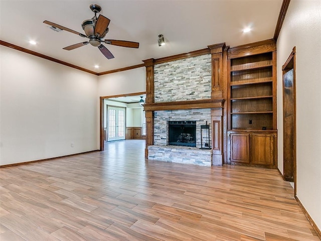 unfurnished living room featuring a stone fireplace, ceiling fan, ornamental molding, and light wood-type flooring