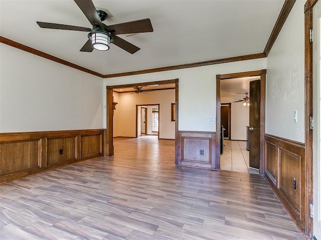 spare room featuring light wood-type flooring and ornamental molding