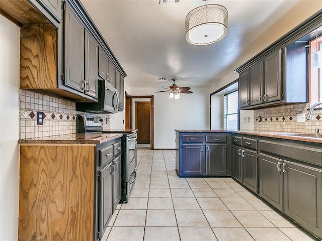 kitchen with sink, ceiling fan, decorative backsplash, light tile patterned floors, and appliances with stainless steel finishes