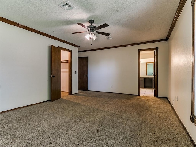 carpeted spare room featuring a textured ceiling, ceiling fan, and ornamental molding