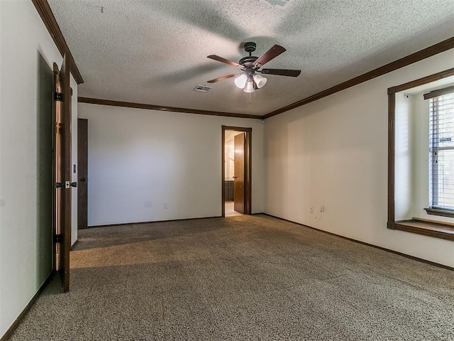 carpeted spare room with a textured ceiling, ceiling fan, a healthy amount of sunlight, and crown molding