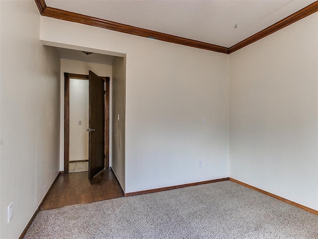 unfurnished room featuring dark colored carpet and crown molding