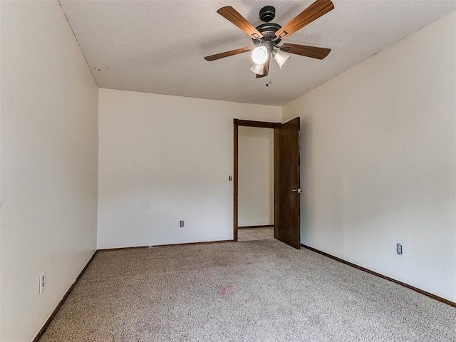 spare room featuring light carpet, a textured ceiling, and ceiling fan