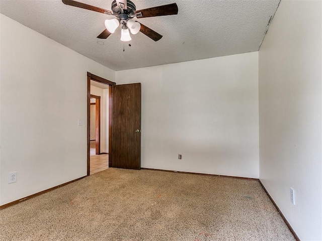 carpeted empty room with ceiling fan and a textured ceiling