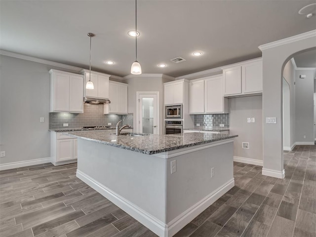 kitchen featuring stainless steel appliances, white cabinetry, and a center island with sink