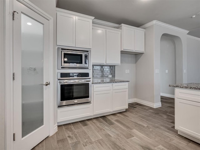 kitchen with white cabinets, stone countertops, and stainless steel appliances