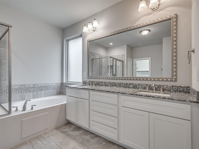 bathroom featuring vanity and independent shower and bath