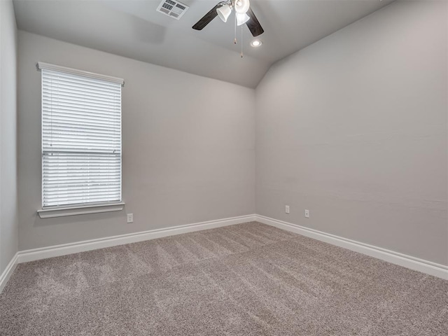 carpeted spare room featuring vaulted ceiling and ceiling fan