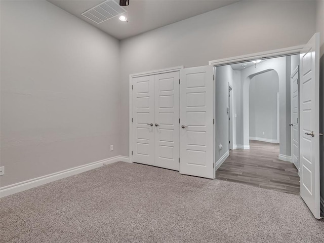 unfurnished bedroom with light colored carpet and a closet