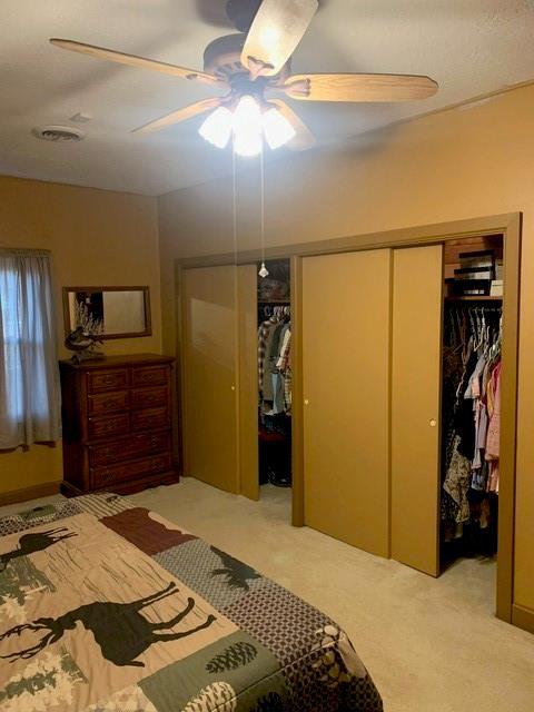 bedroom with ceiling fan and light colored carpet