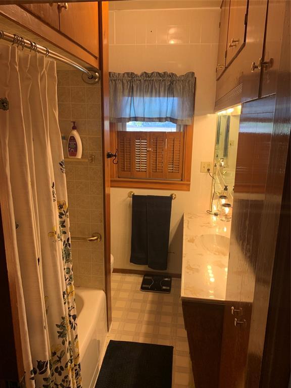 full bathroom featuring toilet, vanity, and shower / bathtub combination with curtain