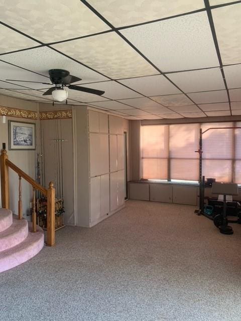 basement with ceiling fan and carpet