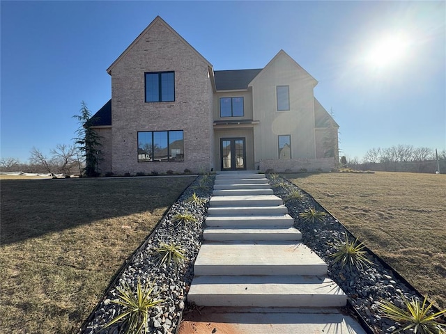 view of front of house featuring a front lawn and french doors