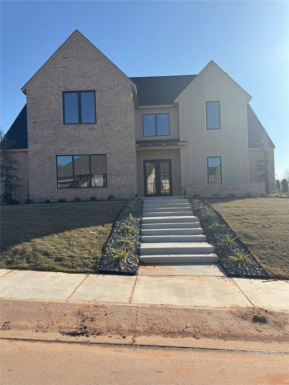 view of front facade with french doors and a front lawn