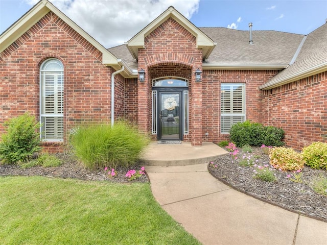 property entrance with a lawn