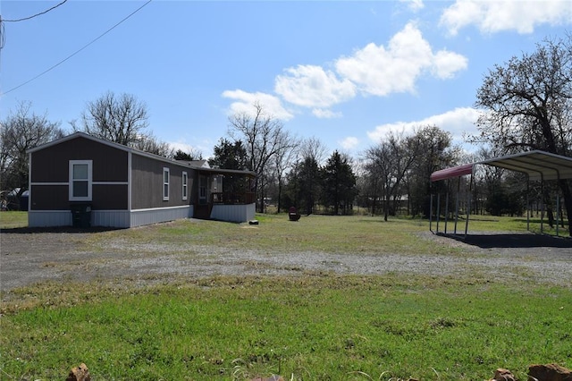 view of yard featuring driveway and a detached carport