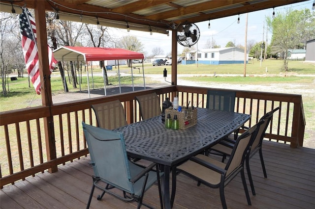 wooden deck featuring outdoor dining space and a yard