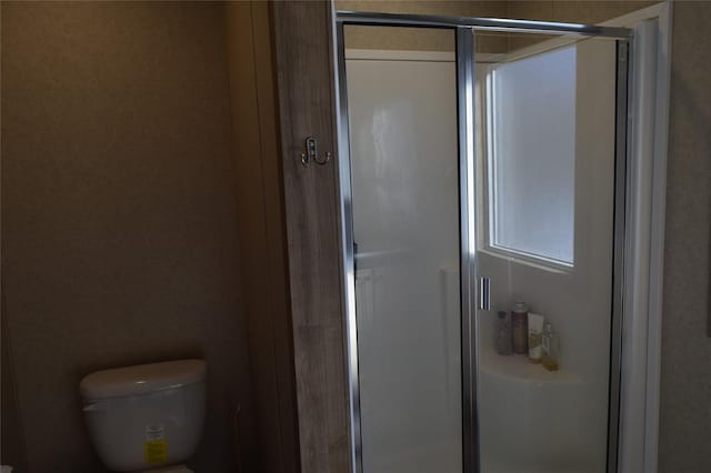 full bath with toilet and a stall shower
