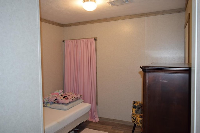 bedroom featuring visible vents and wood finished floors