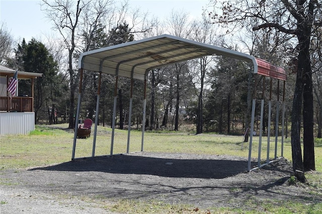 exterior space with a lawn, a detached carport, and driveway