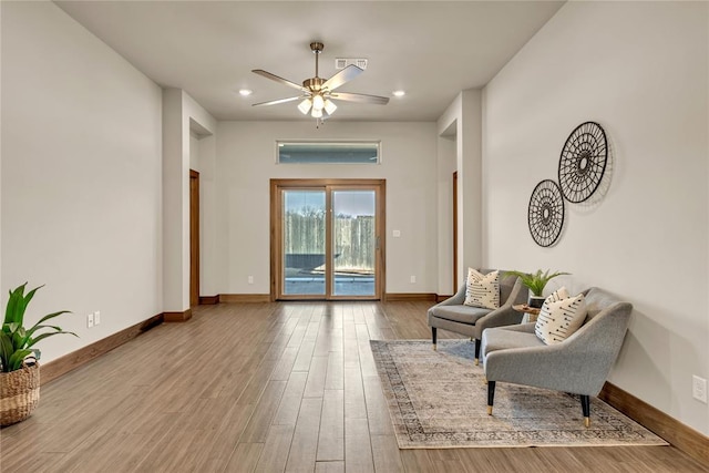 sitting room with hardwood / wood-style flooring and ceiling fan