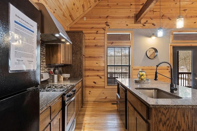 kitchen featuring a center island with sink, wood walls, wooden ceiling, black appliances, and sink