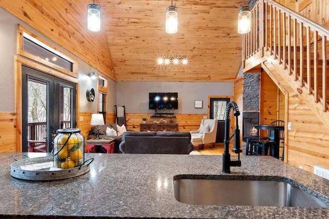 kitchen with sink, wood ceiling, and wooden walls