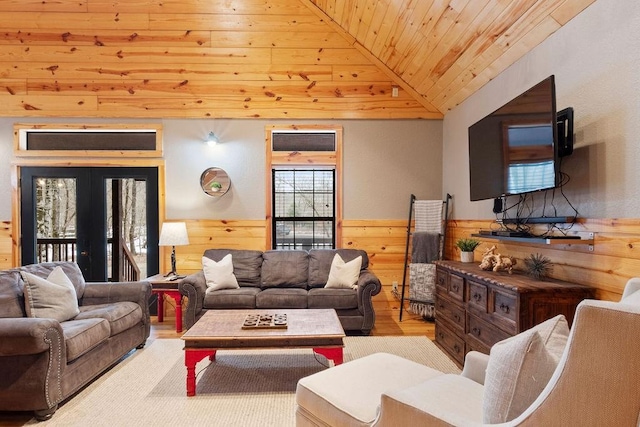 living room with lofted ceiling, light hardwood / wood-style flooring, wooden walls, and wooden ceiling