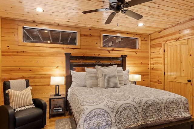 bedroom with ceiling fan, wooden ceiling, and wood walls