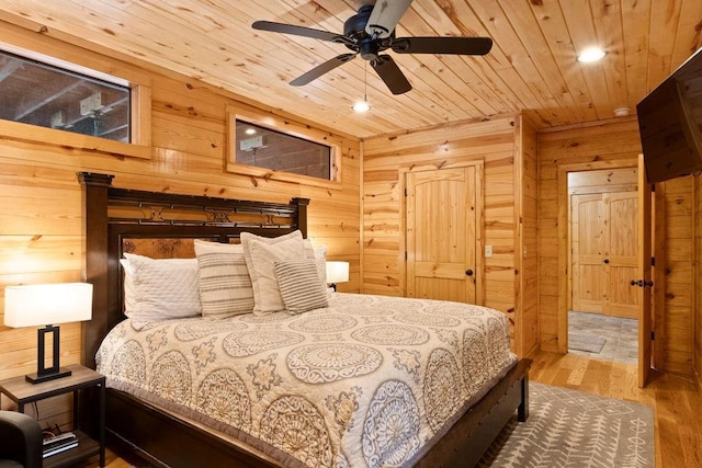 bedroom with ceiling fan, wood-type flooring, wooden walls, and wooden ceiling